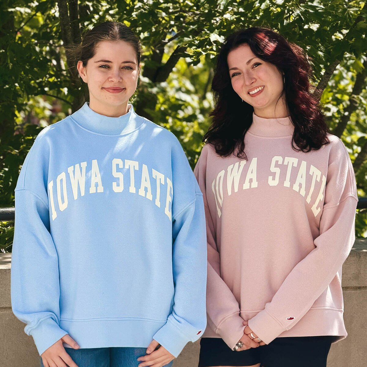A student wearing League Women's Iowa State Dusty Pink Mock Neck Crew Sweatshirt with another student wearing the matching blue version